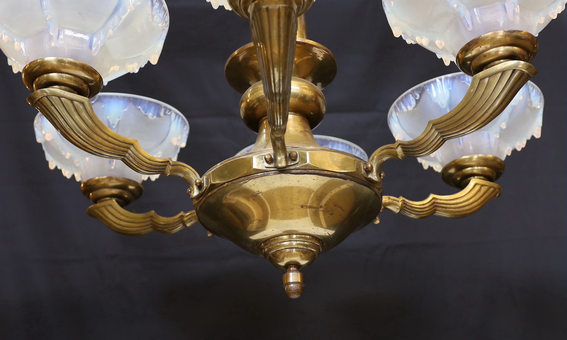 A French Art Deco bronze and opalescent glass six light chandelier by Ezan, with scrolling branches and ‘melting ice‘ shades, height 80cm. width 70cm